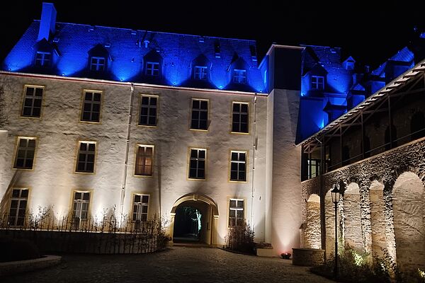 Farbig illuminierte Fassade von Schloß Dhaun bei Nacht