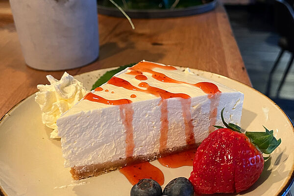 Cheesecake-Schnitte mit Obstgarnitur im Restaurant Bottle 'n Beef