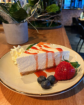 Cheesecake-Schnitte mit Obstgarnitur im Restaurant Bottle 'n Beef